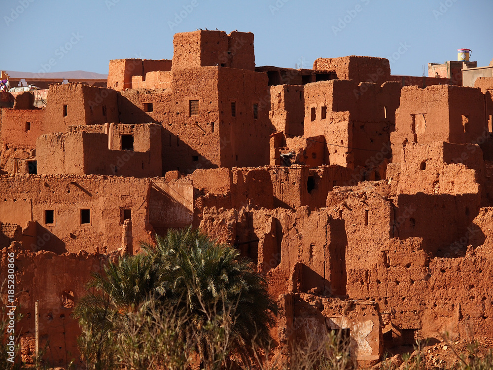 The ancient moroccan town near Tinghir consisting of the clay made adobe kasbahs in front of gorgeous brown high Atlas mountains (Gorge du Dades) - Africa, Morocco 