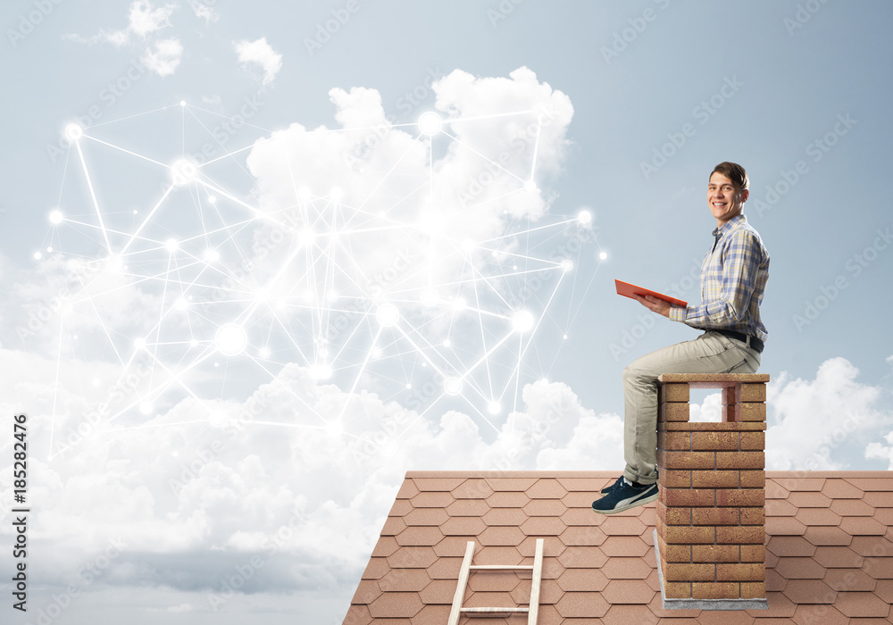Man on brick roof reading book and concept of social connection Man on brick roof reading book and concept of social connection