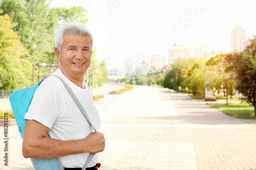 Mature man with mat, outdoors