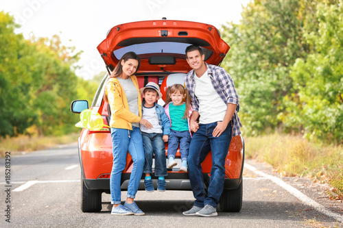 Happy family near car on th...