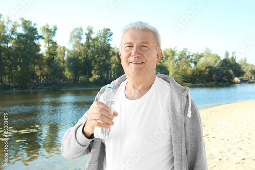 Mature man with bottle of w...