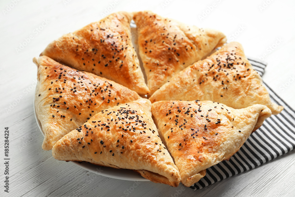 Delicious baked samosas with sesame seeds on light background Delicious baked samosas with sesame seeds on light background
