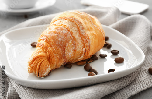 Plate with tasty croissant on table  closeup