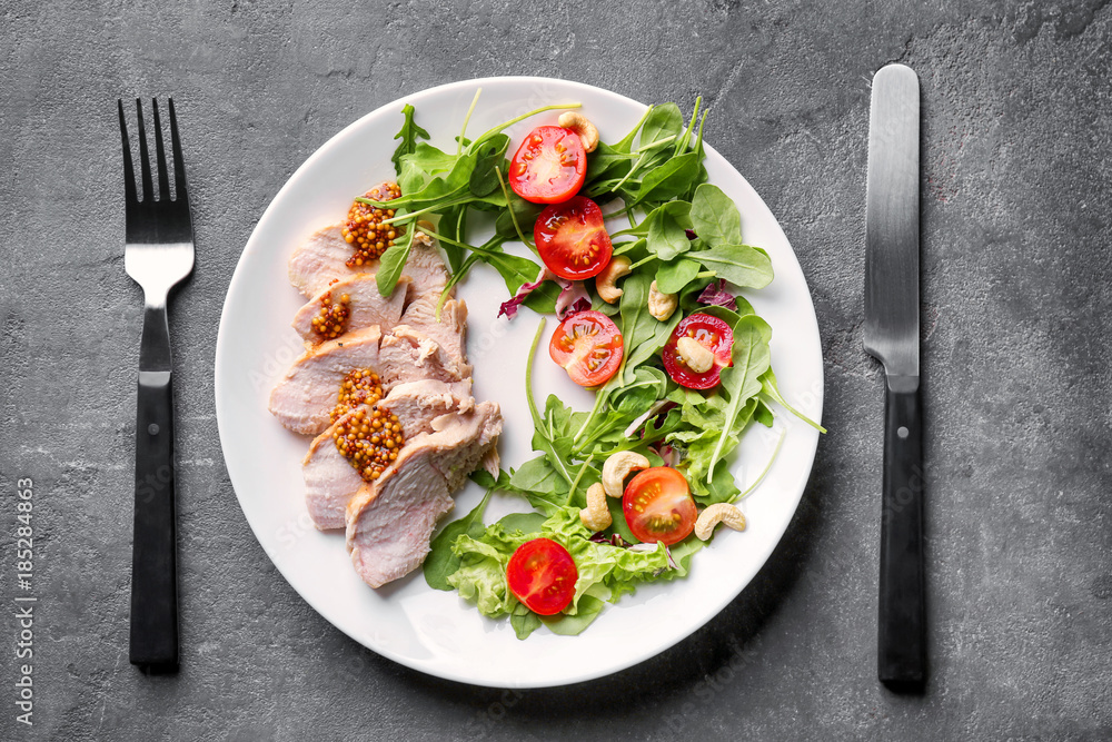 Plate with meat and delicious vegetable salad on grey background, top view Plate with meat and delicious vegetable salad on grey background, top view
