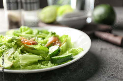 Plate with delicious fresh salad on table, closeup