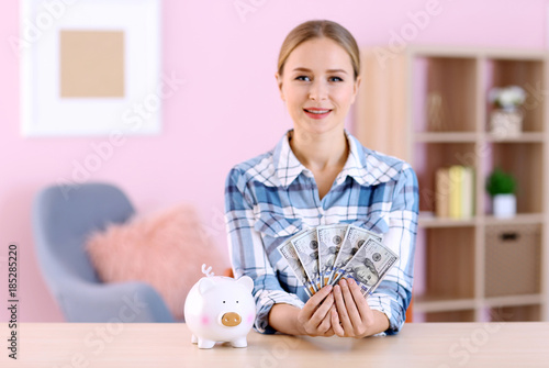Young woman with piggy bank...