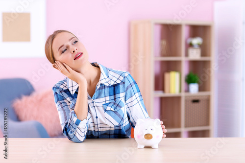 Young woman with piggy bank...
