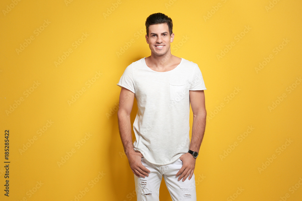 Handsome young man in casual clothes on color background