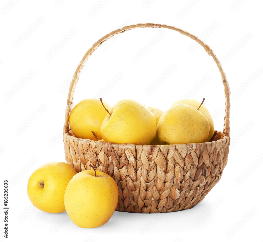 Wicker basket with ripe yellow apples on white background Wicker basket with ripe yellow apples on white background