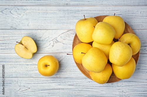 Ripe yellow apples on wooden background, top view