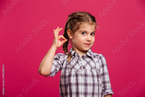 Happy little girl child showing okay gesture.