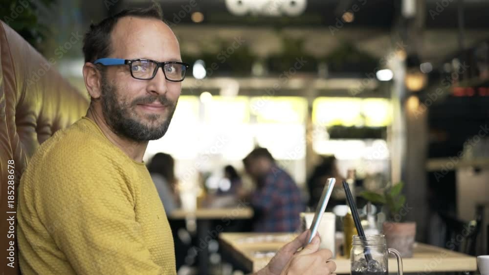 Portrait of happy, young man with tablet sitting in cafe
Portrait of happy, young man with tablet sitting in cafe