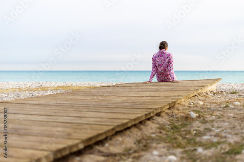 A young woman is sitting on a beach