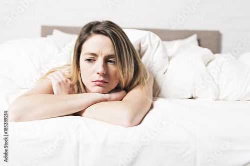 unhappy mature female in bed at bedroom