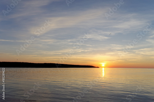 A view of the calm golden sunset on the river with the sun reflected in it  Volga  Russia