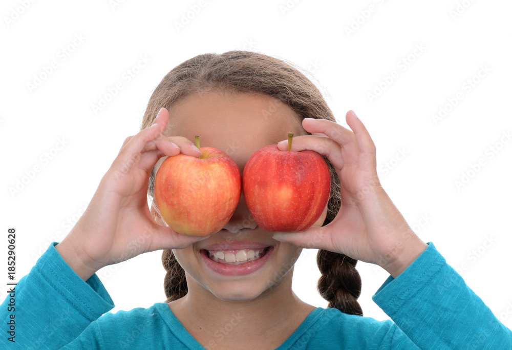Girl holding apples over eyes with a smiley face Girl holding apples over eyes with a smiley face