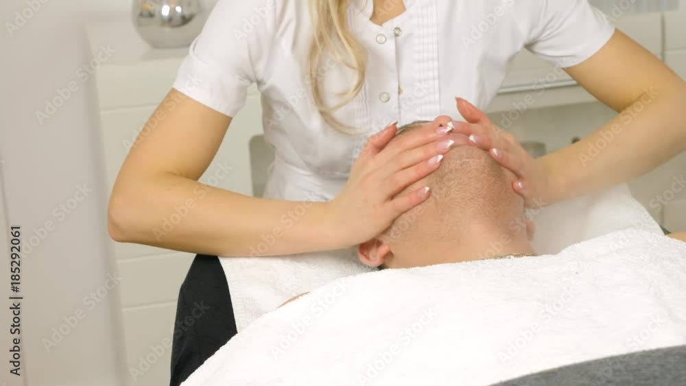 Cosmetologist is doing procedure of face massage for young boy / man. Model, close-up. Cosmetological clinic. Healthcare Cosmetologist is doing procedure of face massage for young boy / man. Model, close-up. Cosmetological clinic. Healthcare