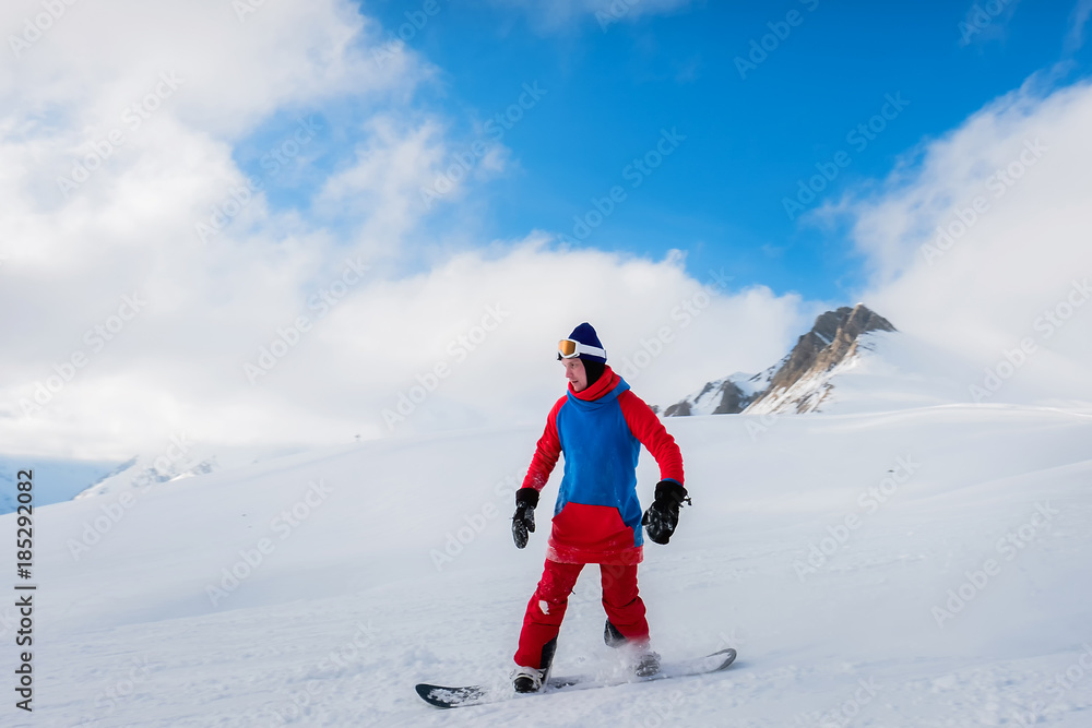 Stylish male athlete snowboarder rides on a blackboard on the snow
