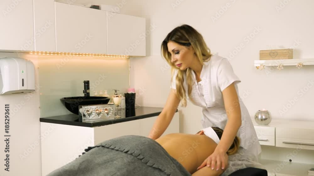 Cosmetologist/Therapist is doing body massage for young girl, woman. Model. Cosmetological clinic. Healthcare Cosmetologist/Therapist is doing body massage for young girl, woman. Model. Cosmetological clinic. Healthcare