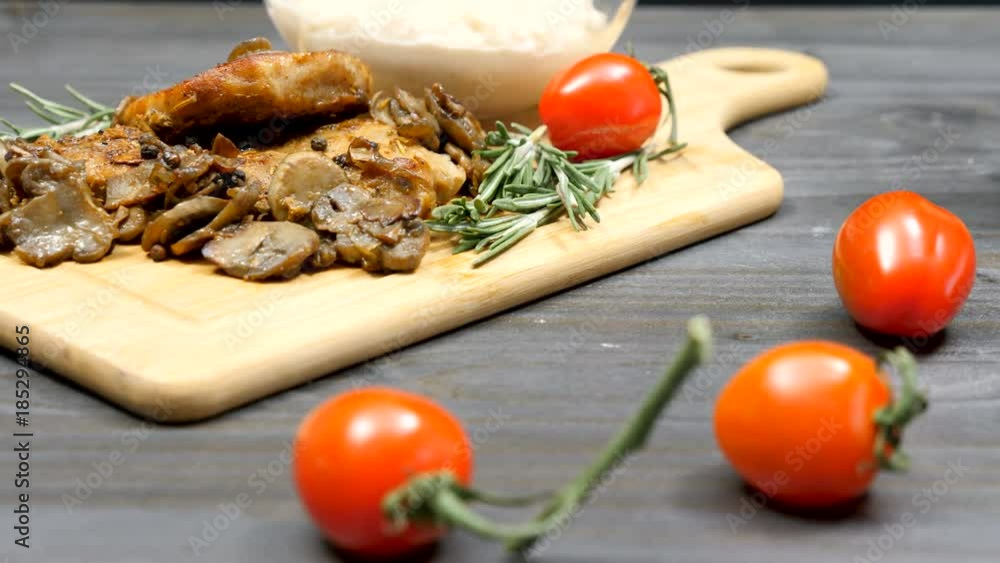 Dolly shot of pork chops with grilled mushrooms, bean pasta and cherry tomatoes on a table Dolly shot of pork chops with grilled mushrooms, bean pasta and cherry tomatoes on a table