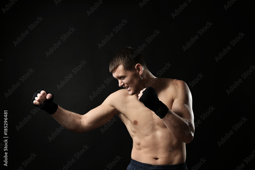 Attractive young boxer on black background
