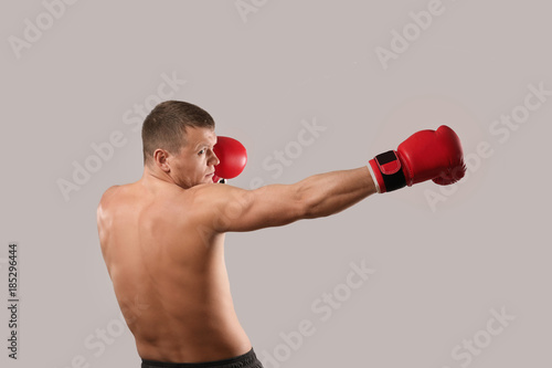 Attractive young boxer on grey background © Africa Studio