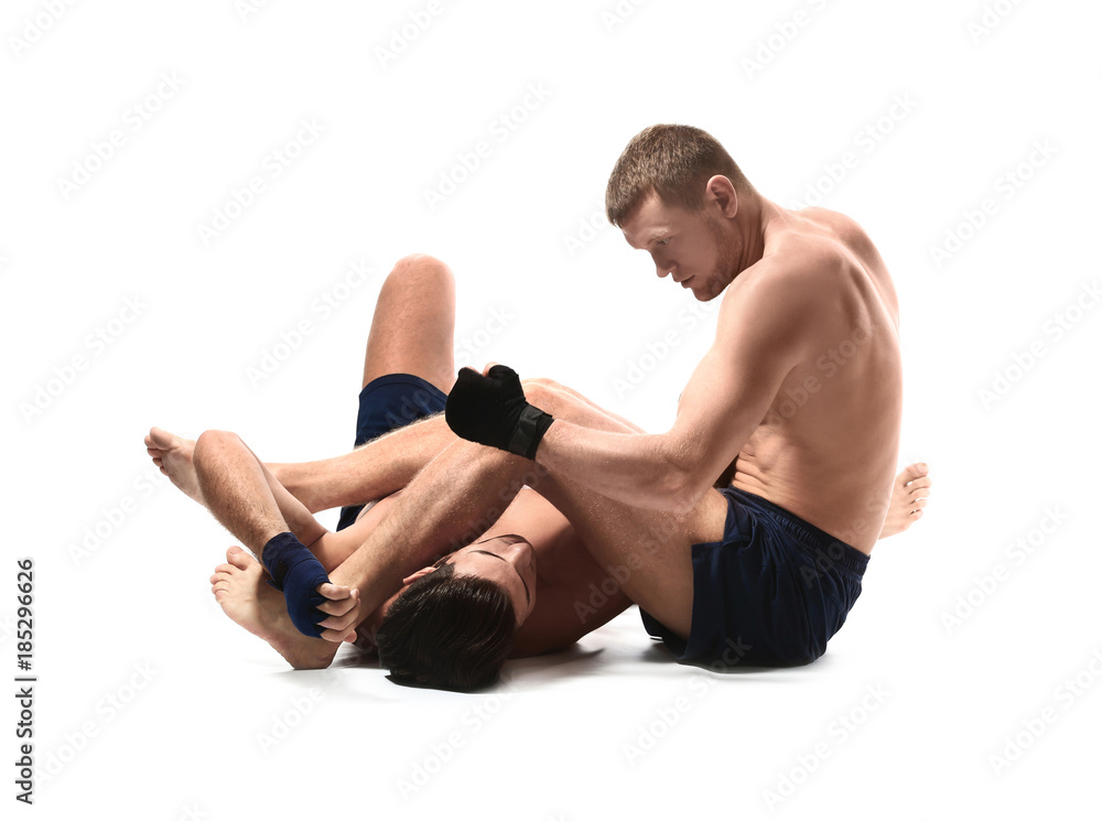 Attractive young men wrestling on white background Attractive young men wrestling on white background