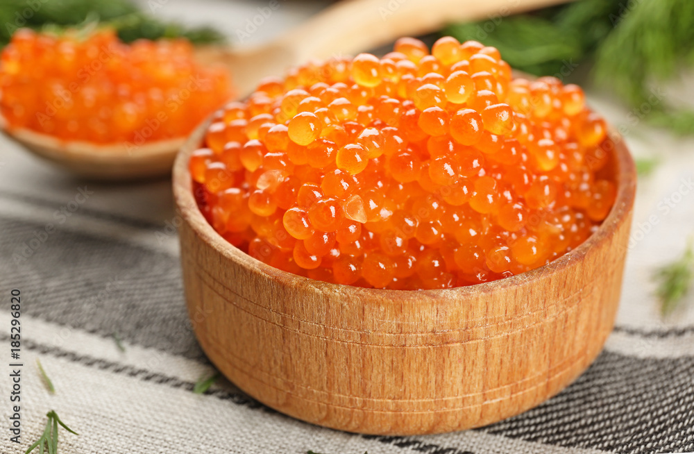 Wooden bowl with delicious red caviar on table Wooden bowl with delicious red caviar on table