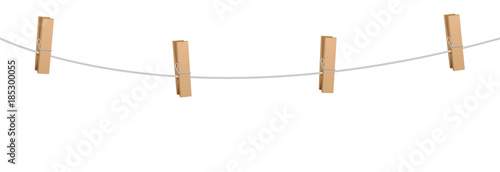 Clothes pins on a clothes line rope  - four wooden pegs holding nothing. photo