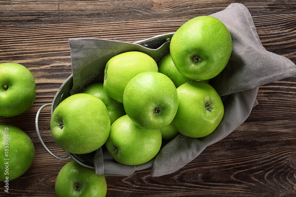 Basket with fresh green apples on wooden background Basket with fresh green apples on wooden background