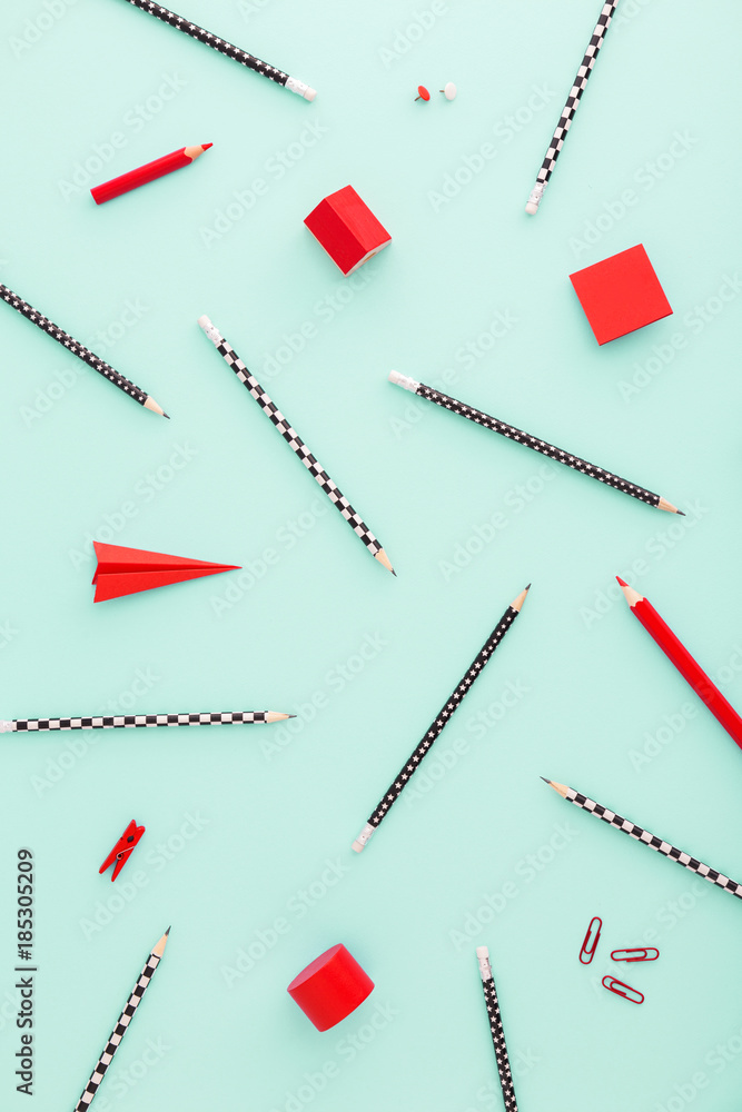 School stationery pencils, crayons, rubber, sticky note in a red color on pastel blue background with copy space School stationery pencils, crayons, rubber, sticky note in a red color on pastel blue background with copy space
