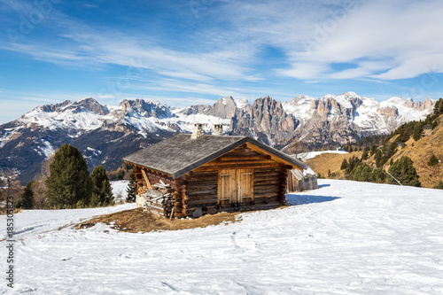 Alpine cottage nearby skiing slopes in Buffaure ski area, Val di Fassa valley, Dolomites mountains, Italy