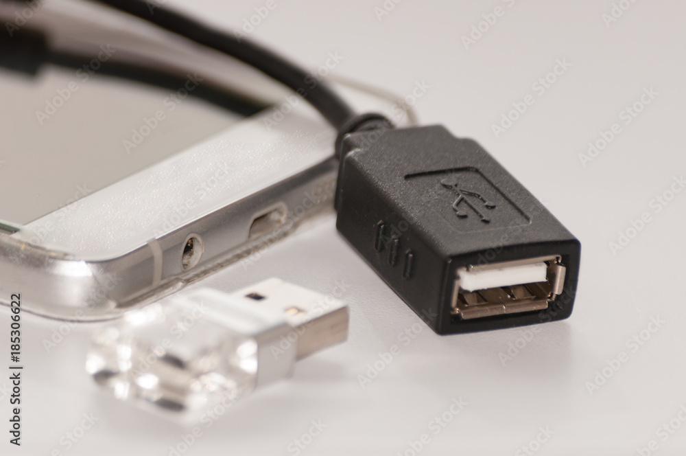 The smartphone next to which is usb flash memory and a cable for its connection to the smartphone. The smartphone next to which is usb flash memory and a cable for its connection to the smartphone.