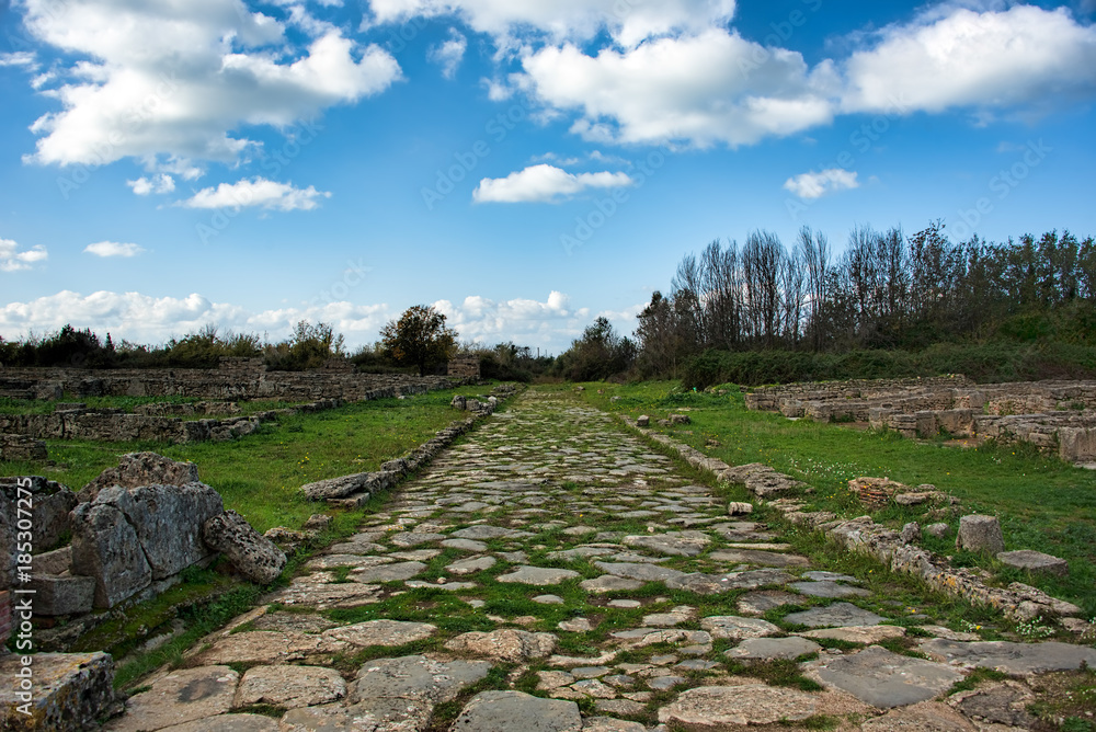 Antique street under blue skies with fluffy white clouds in an a