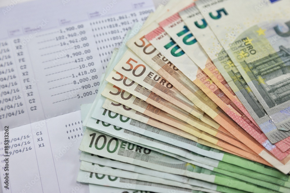 Many euro banknotes and bank account passbook show a lot of transactions. concept and idea of saving money, investment, interest, bank loan, inflation, expenses Many euro banknotes and bank account passbook show a lot of transactions. concept and idea of saving money, investment, interest, bank loan, inflation, expenses