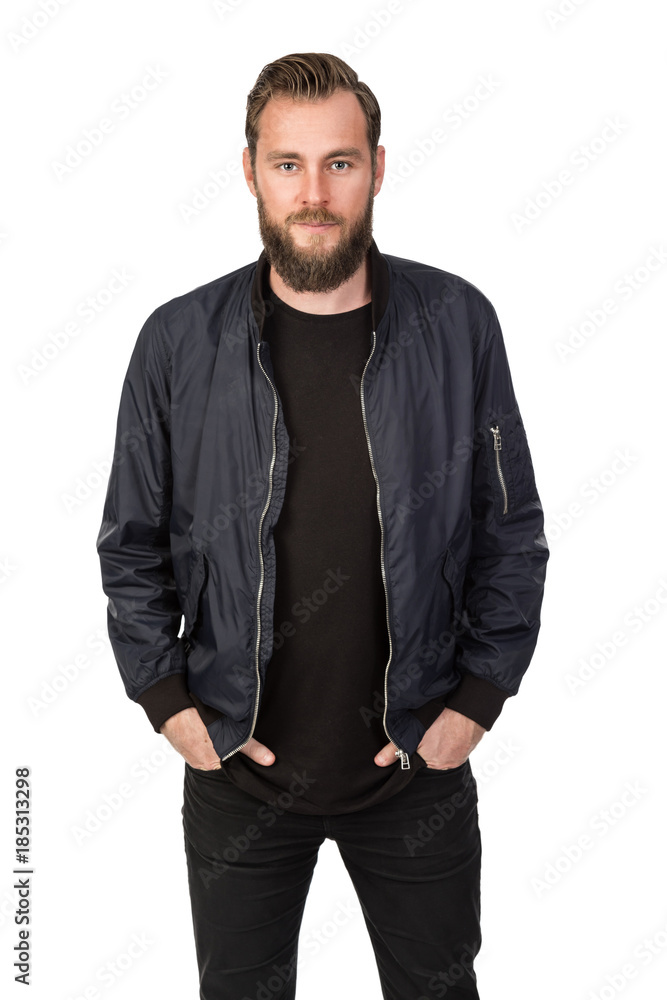 Handsome bearded man standing against a white background wearing a black tshirt and blue jacket in jeans. Looking at camera. Handsome bearded man standing against a white background wearing a black tshirt and blue jacket in jeans. Looking at camera.