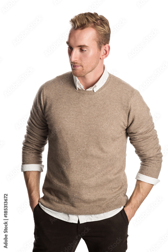 Trendy blonde man standing against a white background in brown pullover shirt. White background. Trendy blonde man standing against a white background in brown pullover shirt. White background.