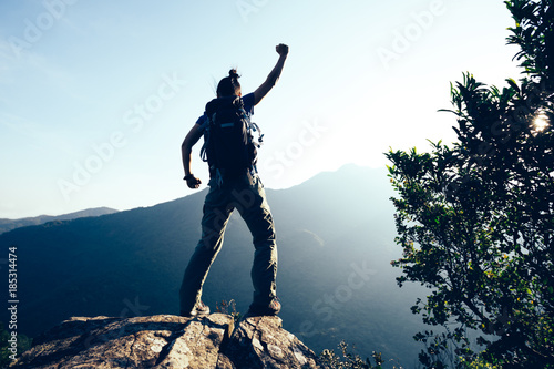 successful female hiker standing on cliff's edge