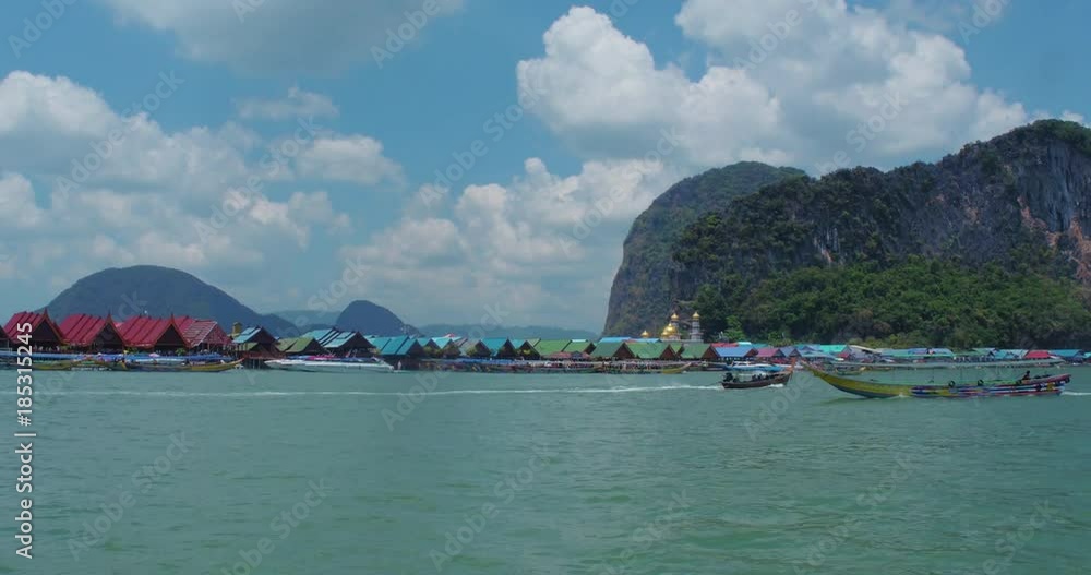 PHUKET, THAILAND, MARCH 2017: Ko Panyi floating village, viewed from boat in motion. PHUKET, THAILAND, MARCH 2017: Ko Panyi floating village, viewed from boat in motion.