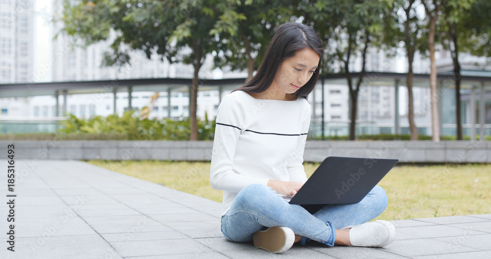 Fototapeta premium Asian Woman work on notebook computer and use of cellphone