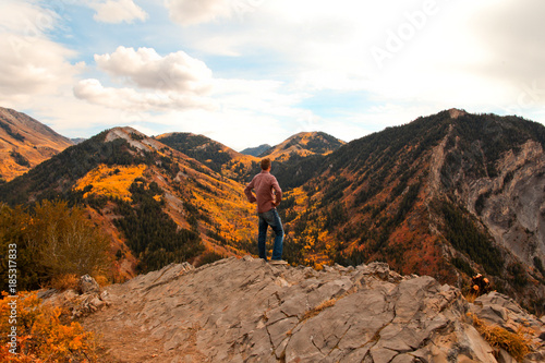 Man stands and admires the fall colors in view