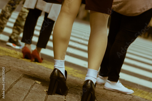Close-up of fashionable and pretty female legs waiting to cross the road in Shibuya, Tokyo, Japan