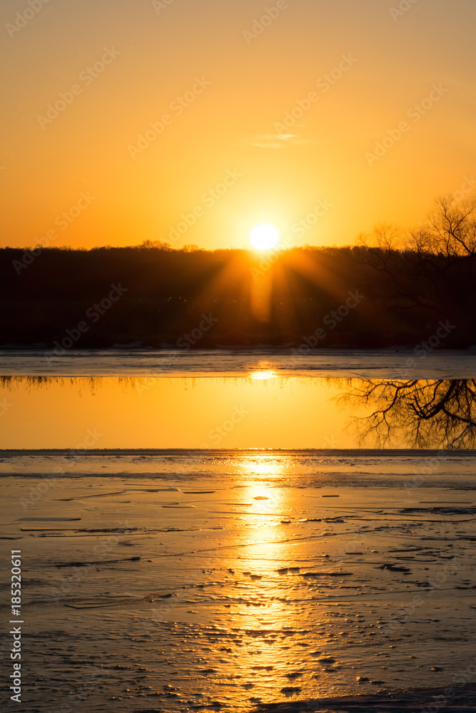 Golden hour sunset reflecting on icy river