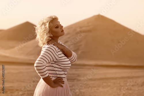 fat plus model girl with curly blond hair in long skirt enjoying warm sunset time in the egyptian sandy desert with sandy pyramids scenery, plus size model, fat woman, fashion