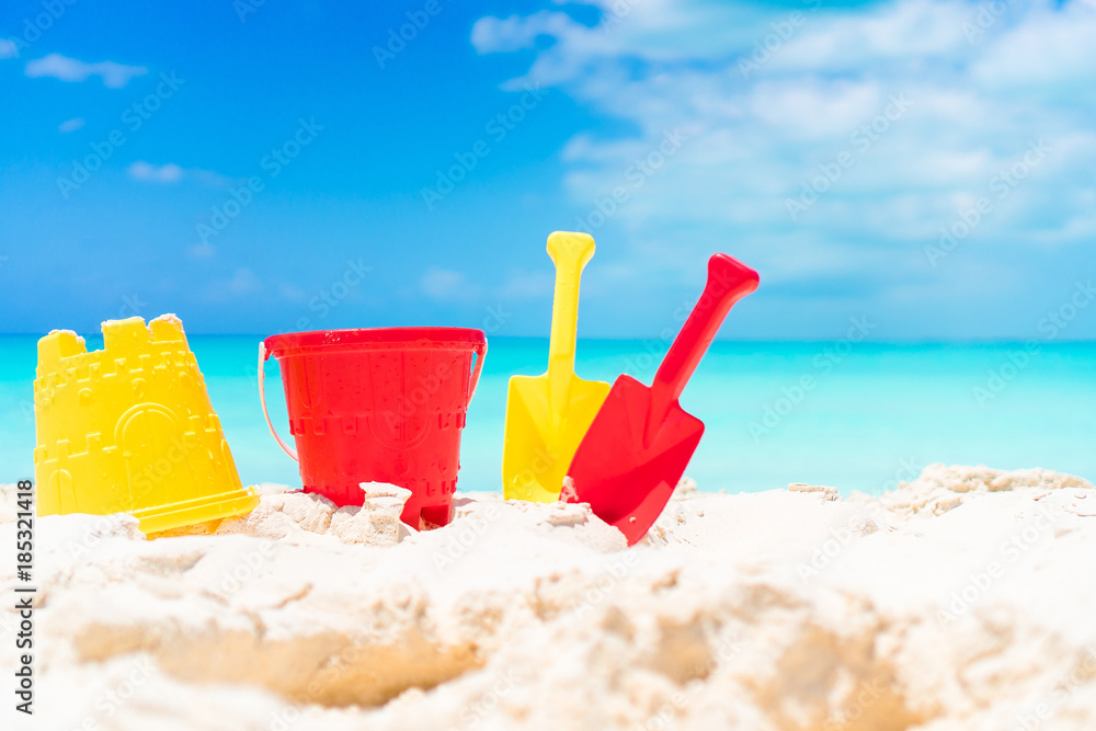Kid's beach toys and straw hat on white sandy beach Kid's beach toys and straw hat on white sandy beach