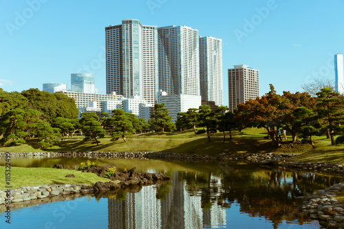 A seawater pond in Hamarikyu Gardens with tall modern buildings in the background