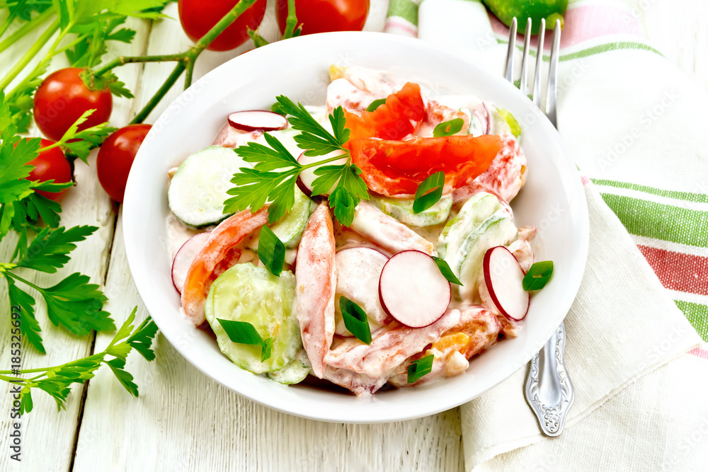 Salad from fresh vegetables with greens in plate on light board Salad from fresh vegetables with greens in plate on light board