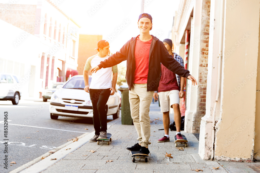 Teenage friends walking at the street with skateboards Teenage friends walking at the street with skateboards