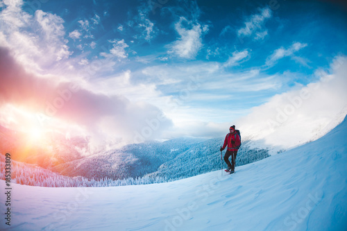 A man in snowshoes in the mountains.