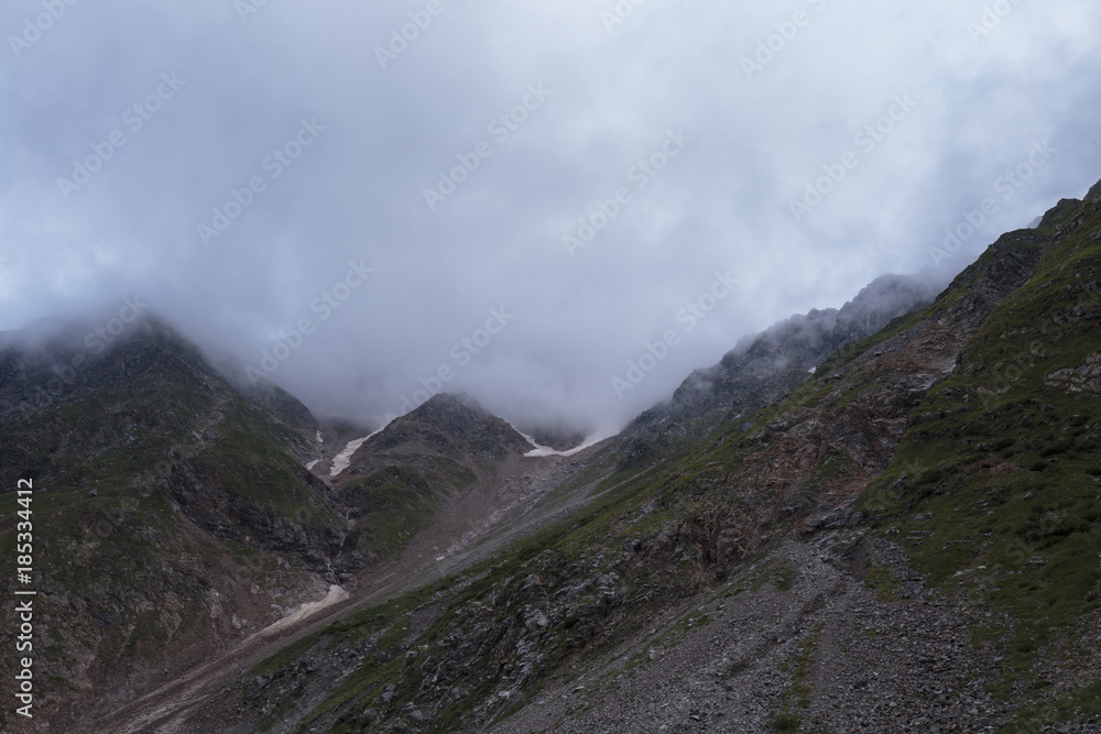 Summer views of the snowy mountains of the Caucasus. Formation and movement of clouds over mountains peaks. Summer views of the snowy mountains of the Caucasus. Formation and movement of clouds over mountains peaks.